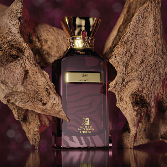 Ahmed Al Maghribi Red Jewel Perfume bottle with gold cap and purple label on a textured surface