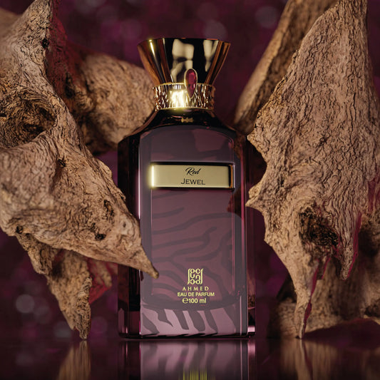 Ahmed Al Maghribi Red Jewel Perfume bottle with gold cap and purple label on a textured surface