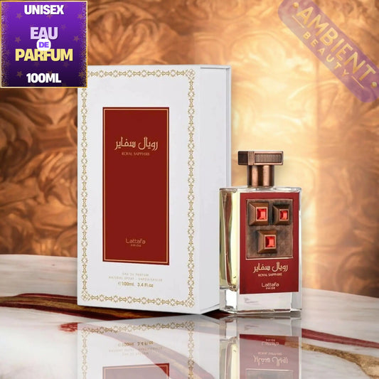 A 100ml bottle of Royal Sapphire Unisex Eau de Parfum next to its white and gold box packaging, displayed on a reflective marble surface with a warm golden background.