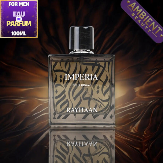 Rayhaan Imperia Pour Homme 100ml perfume bottle, featuring a clear glass rectangular body with black Arabic calligraphy on a beige background, a black cap, and a reflective surface below. The background is a dark, draped brown fabric with a purple 'For Men Eau De Parfum 100ML' badge on the top left and a purple 'Ambient Beauty' badge on the top right.