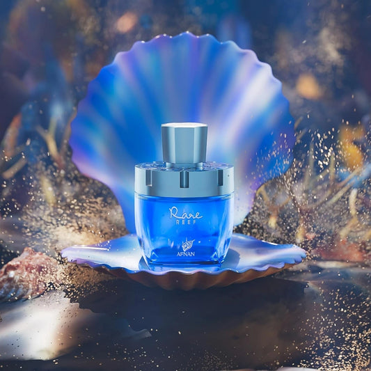 Blue perfume bottle labeled 'Rare Reef' by Afnan on a seashell with a blurred underwater background.