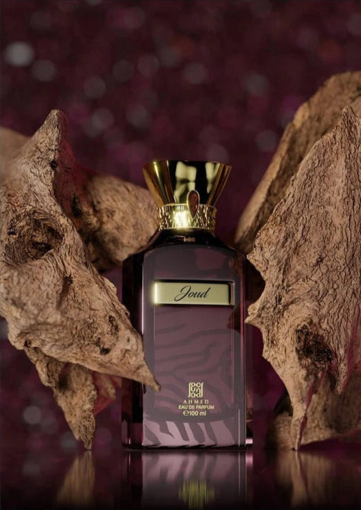 Ahmed Al Maghribi Joud Perfume bottle with gold cap and dark label against a textured brown background