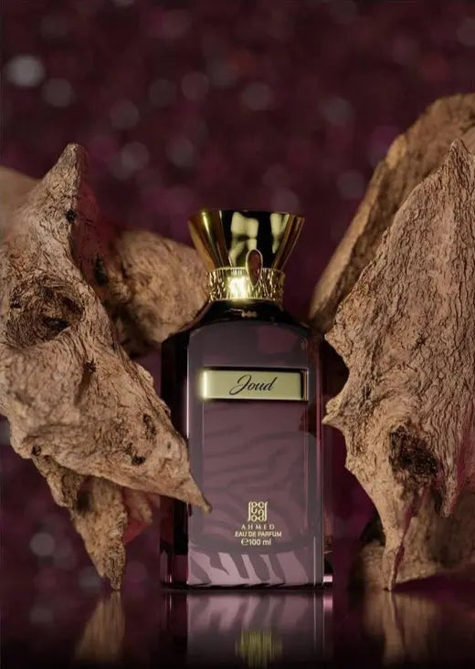 Ahmed Al Maghribi Joud Perfume bottle with gold cap and dark label against a textured brown background