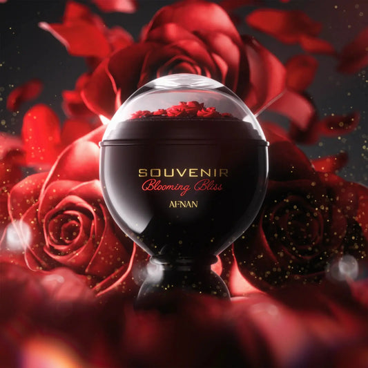 Black perfume bottle labeled 'Souvenir Blooming Bliss' by Afnan surrounded by red roses on a dark background.
