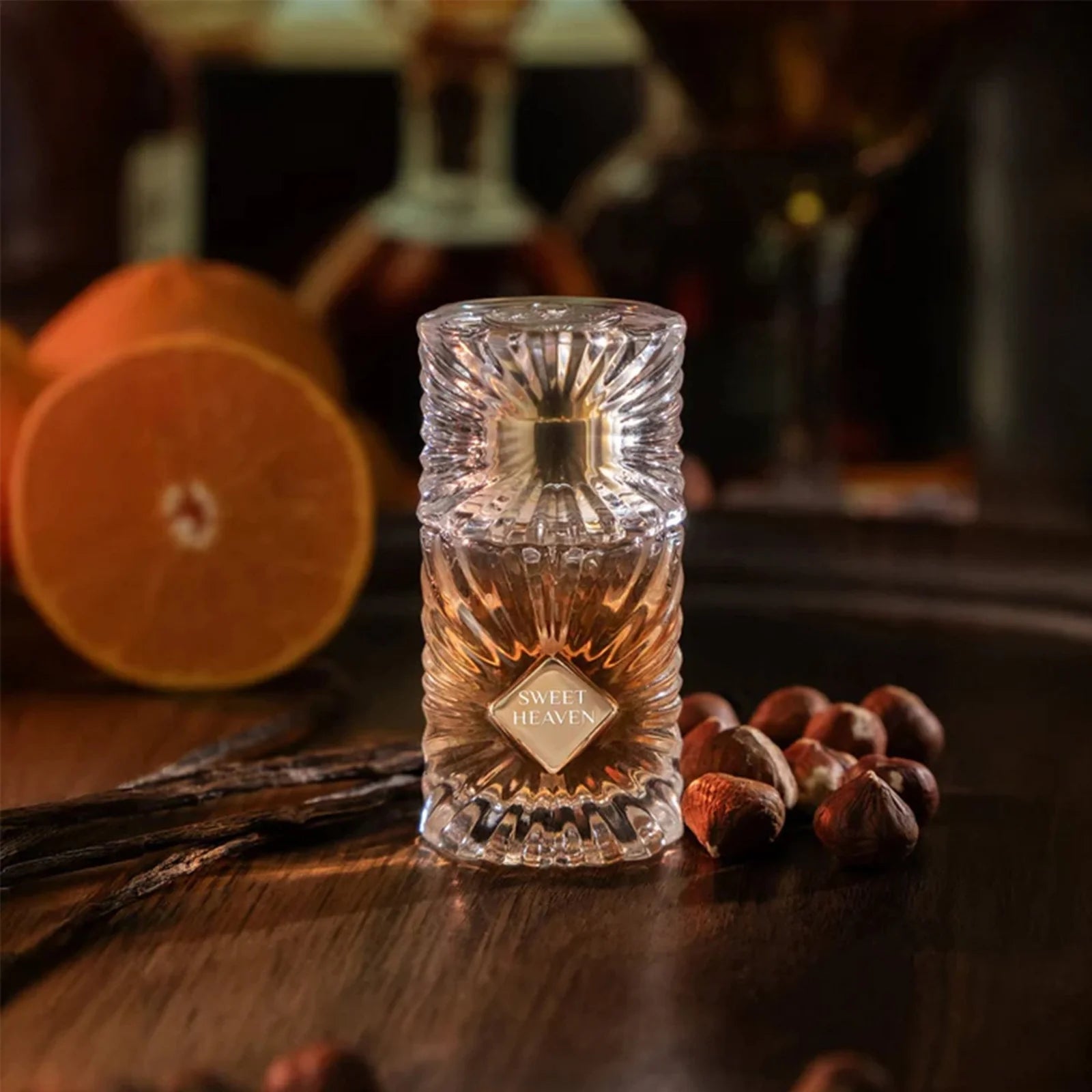 Decorative glass bottle with intricate design on a wooden surface with fruits and spices.