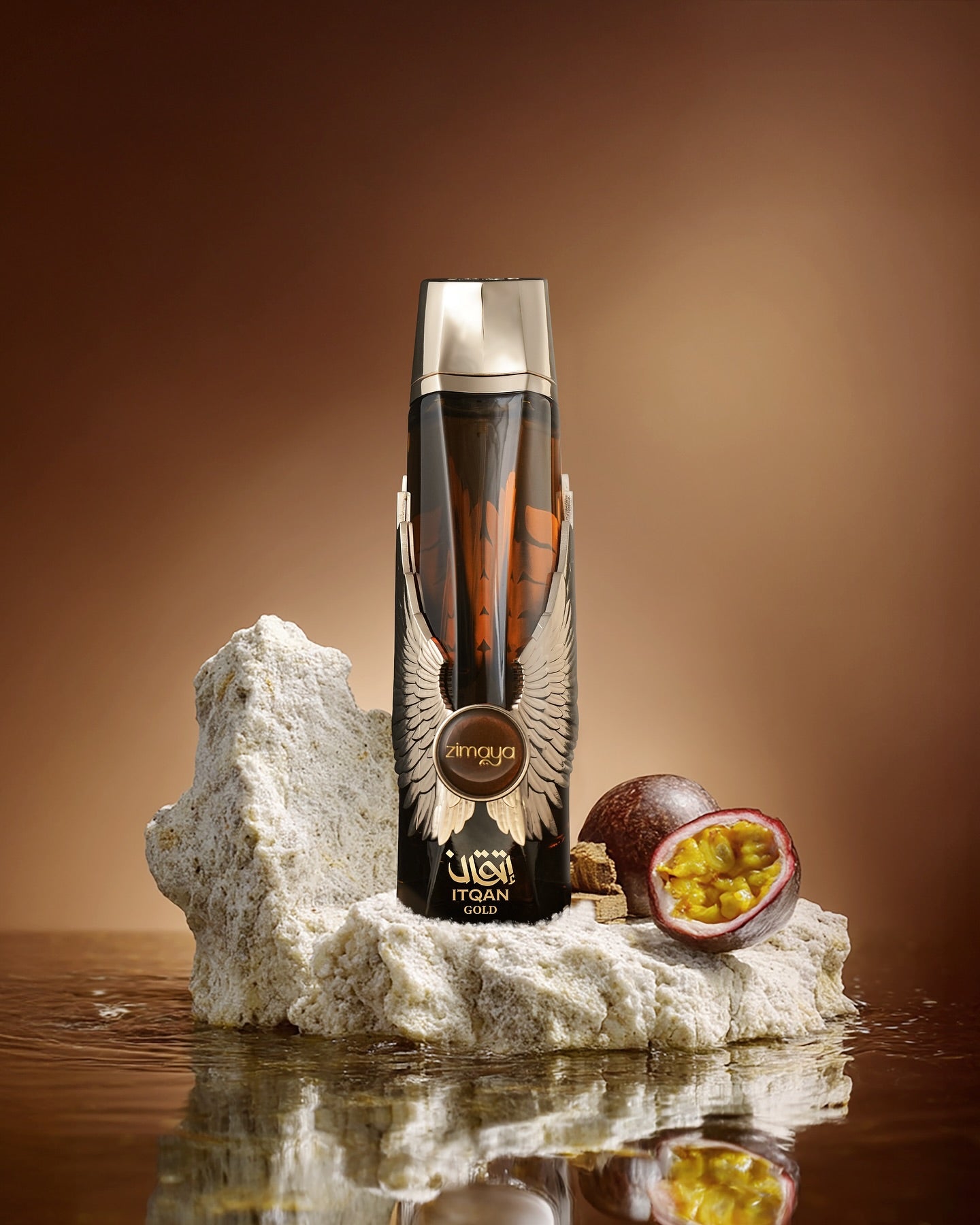 Bottle of Itqan on a rock with a passion fruit on a reflective surface and brown background