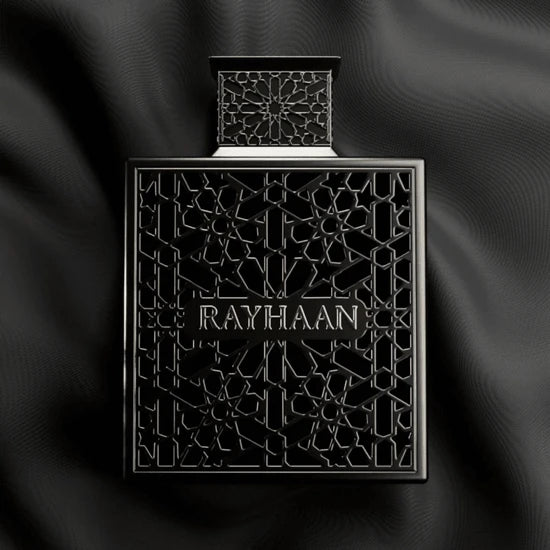 Black perfume bottle with intricate design and 'RAYHAAN' branding on a dark fabric background