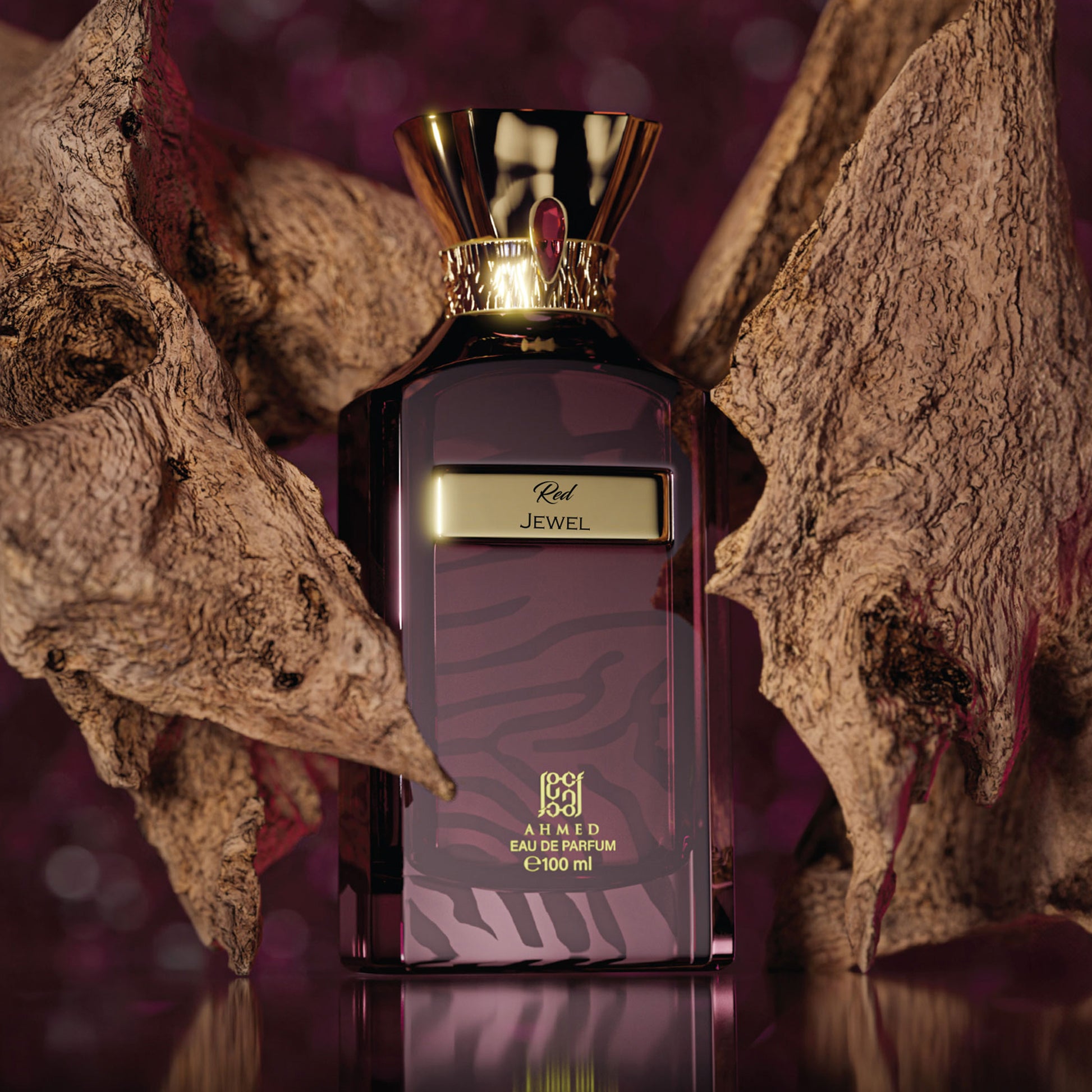 Ahmed Al Maghribi Red Jewel Perfume bottle with gold cap and purple label on a textured surface