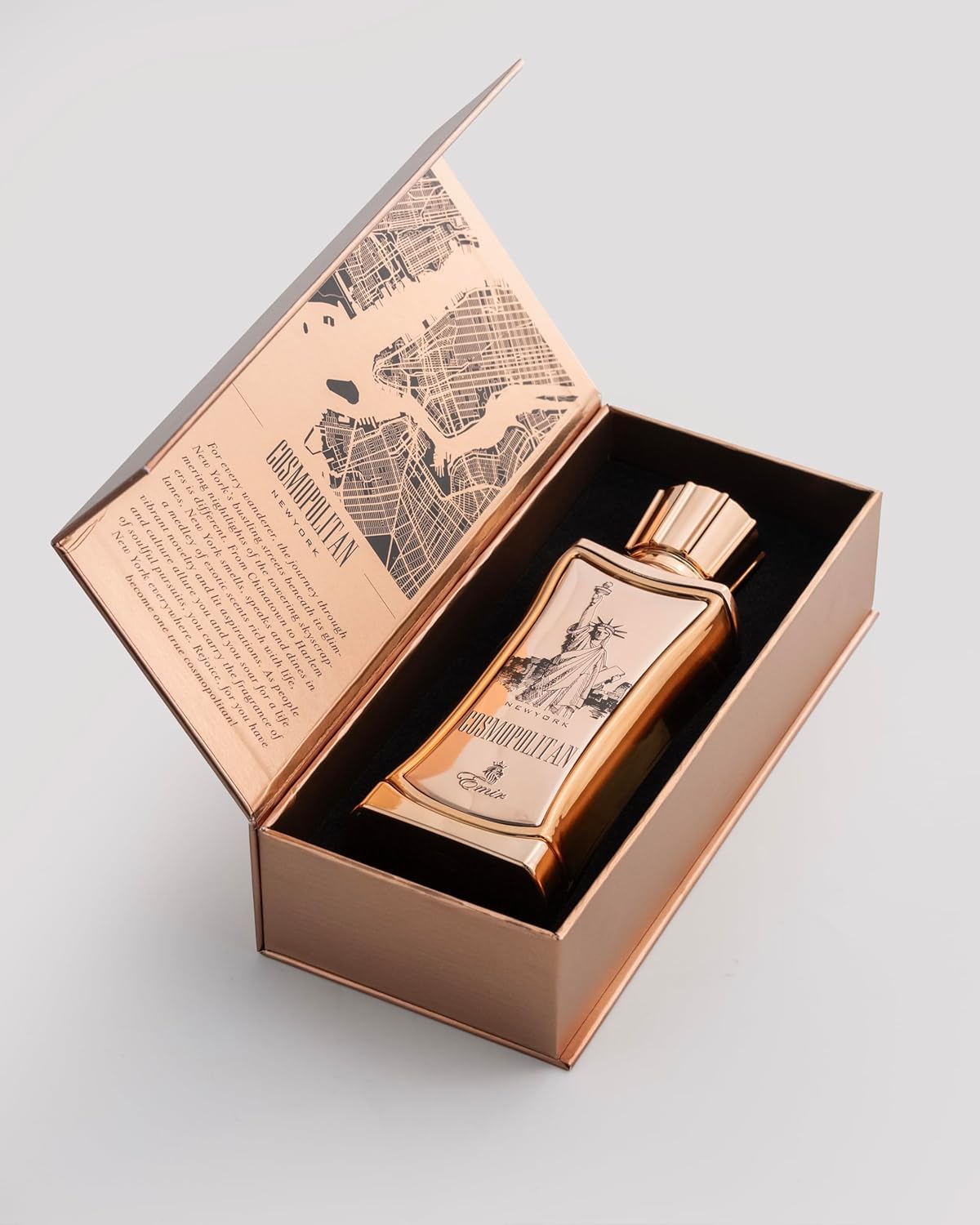 Emir Cosmopolitan New York Bronze bottle with decorative design in an open box on a light gray background