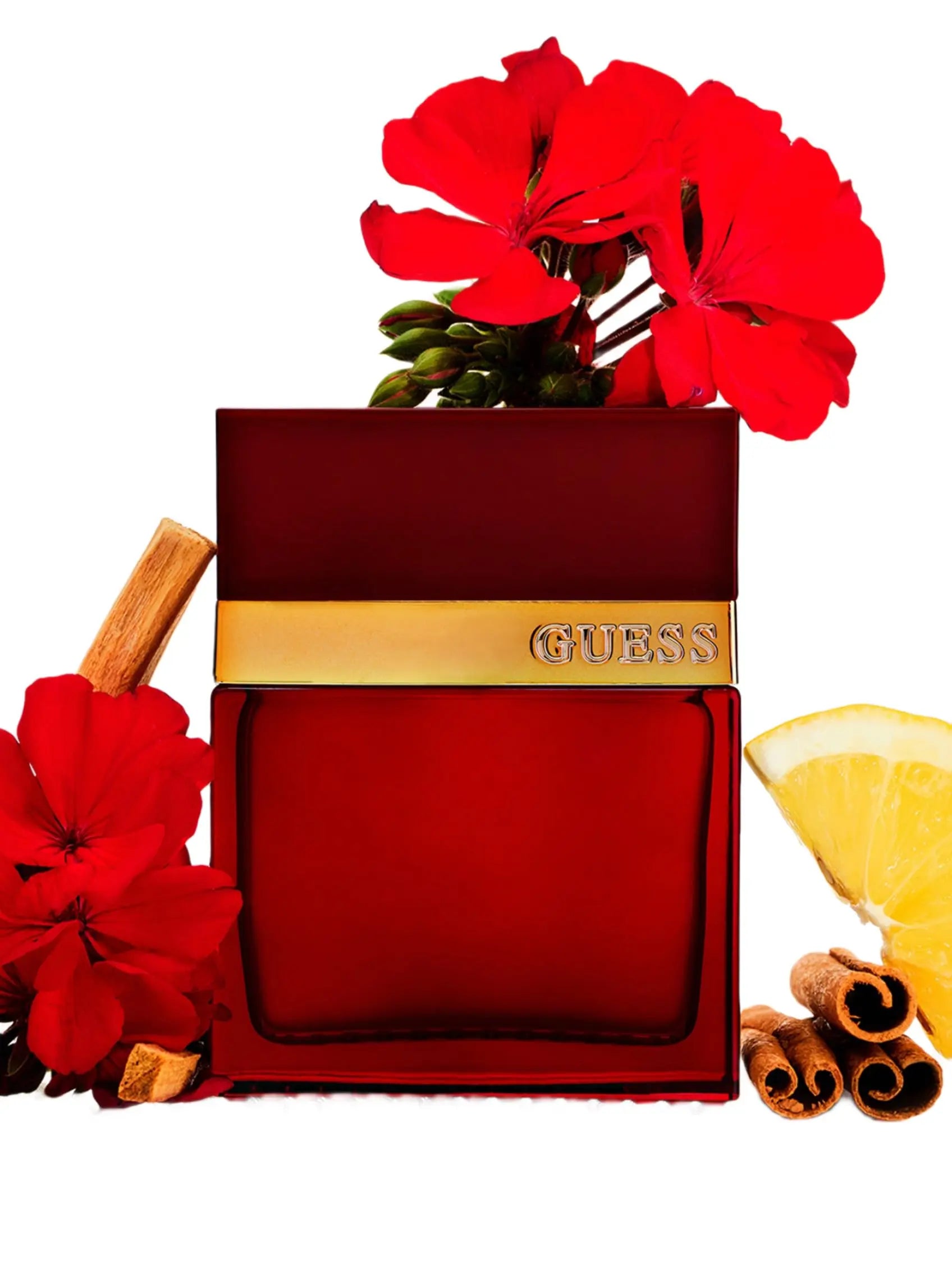 Red Guess perfume bottle with red flowers, cinnamon sticks, and a lemon on a white background