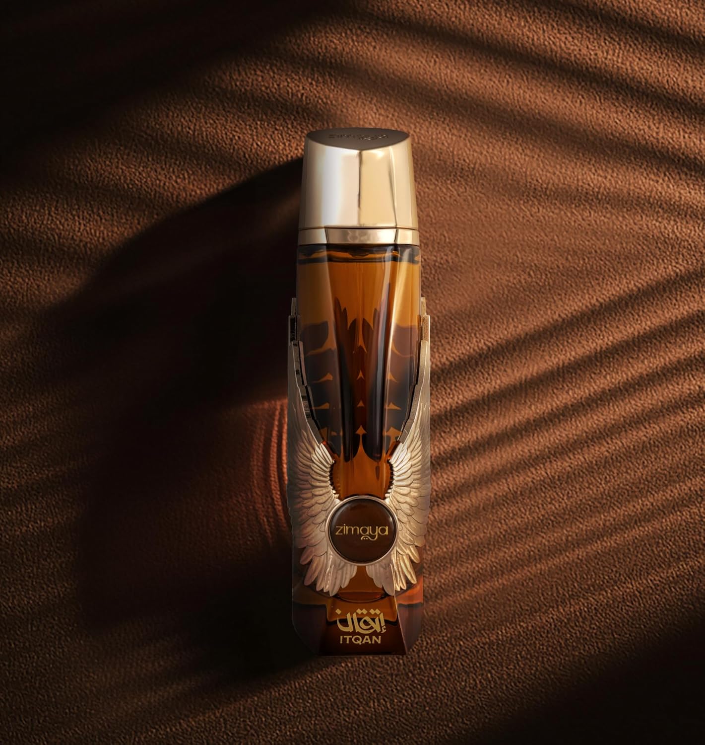 Zimaya Itqan Gold perfume bottle on a textured brown surface