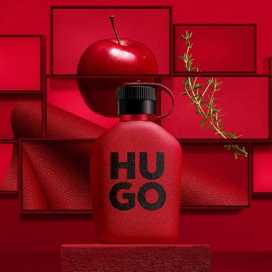 Red 'HUGO' perfume bottle with a black cap on a red background