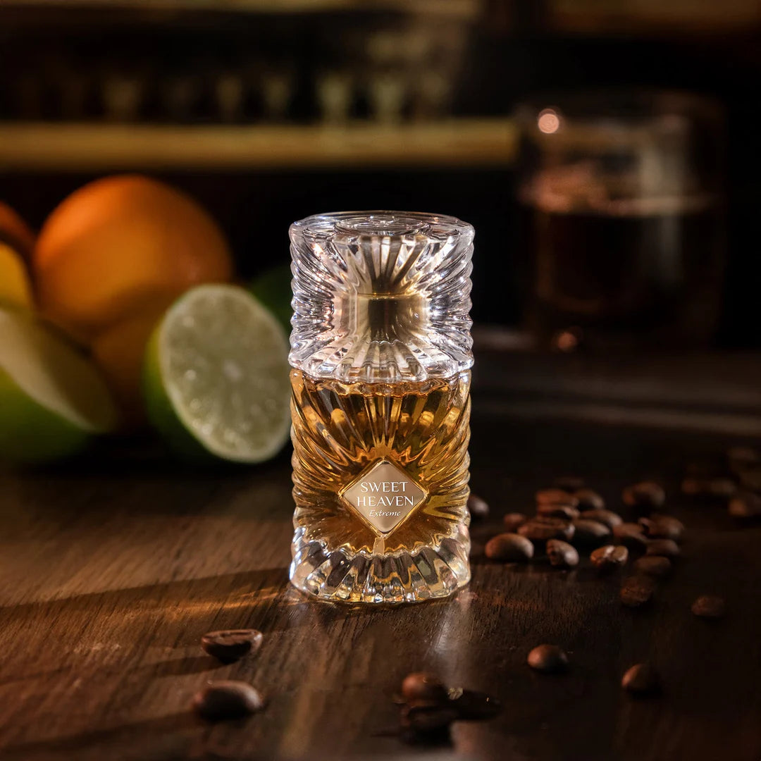 Glass bottle of 'Sweet Heaven exteme' brandy on a wooden surface with fruits and coffee beans in the background