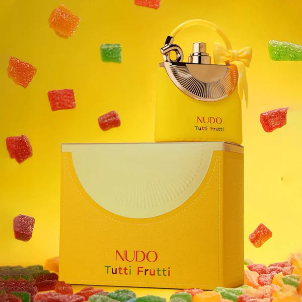 Nudo Tutti Frutti perfume bottle and packaging on a yellow background with gummy bears.