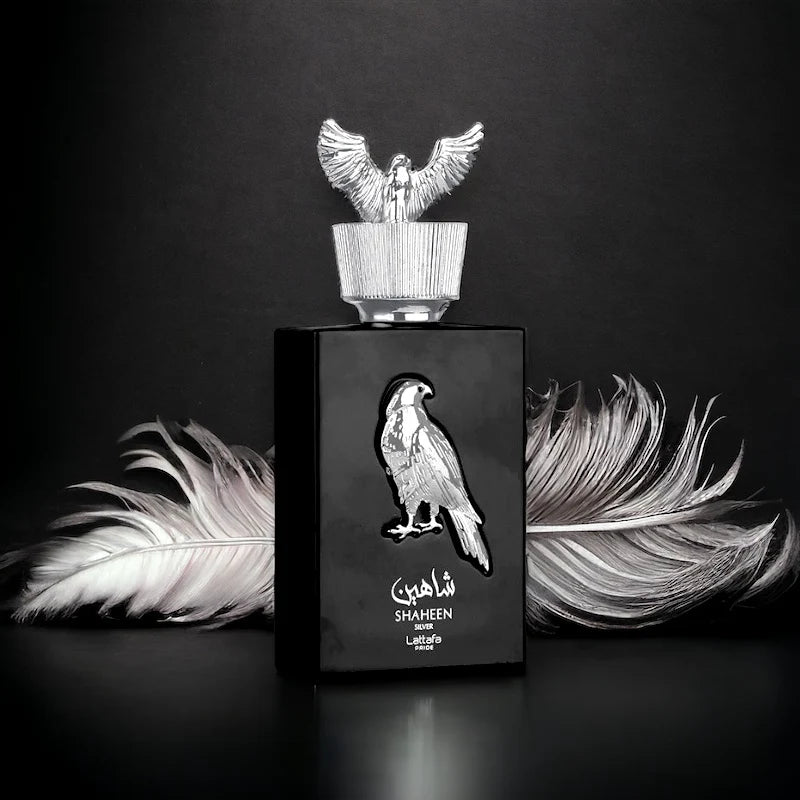 Lattafa Shaheen Silver Perfume bottle with falcon design and feathers on a dark background
