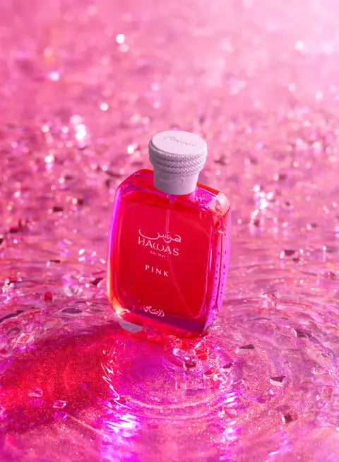 Pink bottle with cork on a glittery pink background