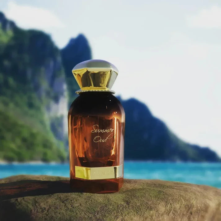 Ahmed Al Maghribi Summer Oud Perfume bottle with gold cap and label on a rock with a mountainous background