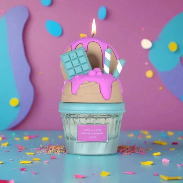 Lattafa Vanilla Freak  Candle shaped like a cupcake with pink frosting and a lit candle, surrounded by colorful confetti on a pink and blue background.