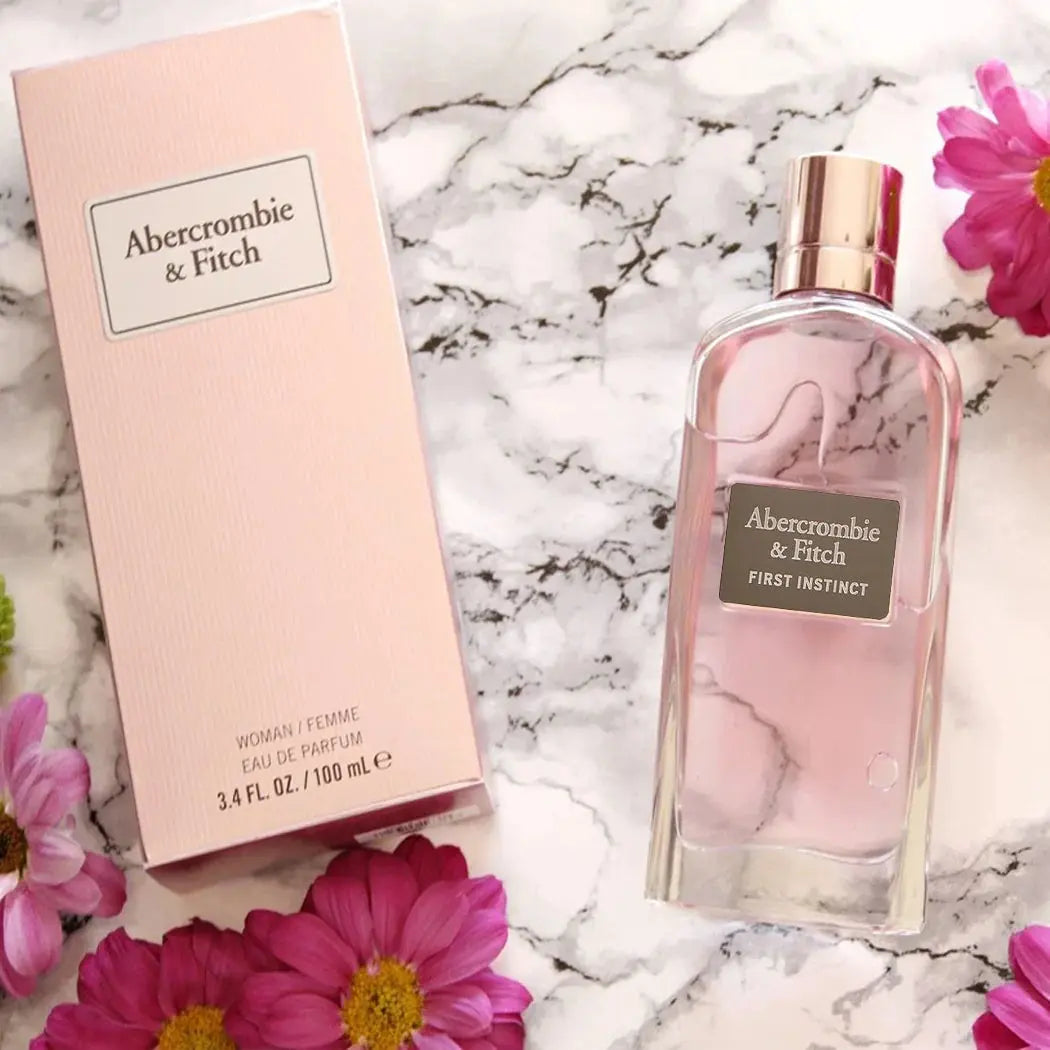 Abercrombie & Fitch perfume bottle and packaging on a marble surface with flowers.