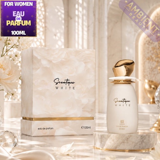 Scentique White Eau de Parfum 100ml bottle with its matching marble-patterned box, displayed on a marble pedestal with decorative flowers and crystals in a bright, elegant setting.