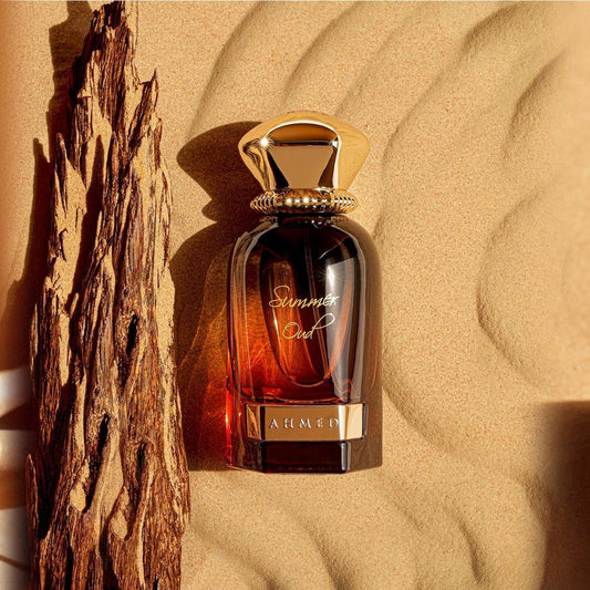Ahmed Al Maghribi Summer Oud Perfume bottle labeled 'Summer Oud' by Alhena on a sandy background with driftwood.