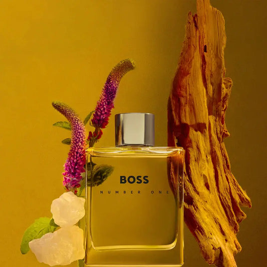 BOSS Number One perfume bottle with flowers and wood on a yellow background