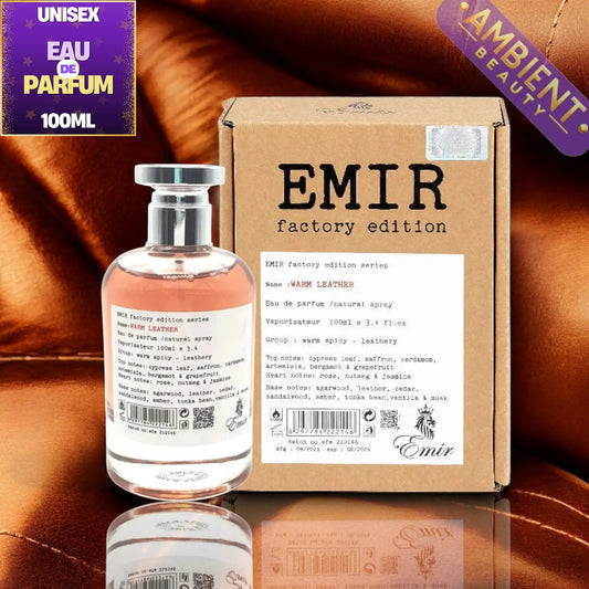 A 100ml bottle of Emir Factory Edition 'Warm Leather' natural spray perfume next to its brown cardboard packaging box, set against a reflective brown leather background with a 'Unisex Eau De Parfum 100ML' badge in the top left corner.