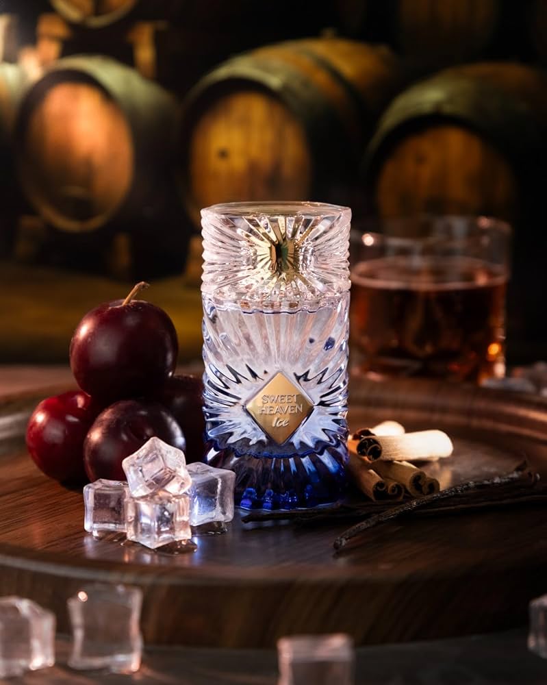 Decorative glass with ice cubes on a wooden surface with apples and barrels in the background