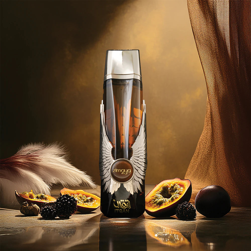 Decorative bottle with wings on a reflective surface, surrounded by fruits and feathers.