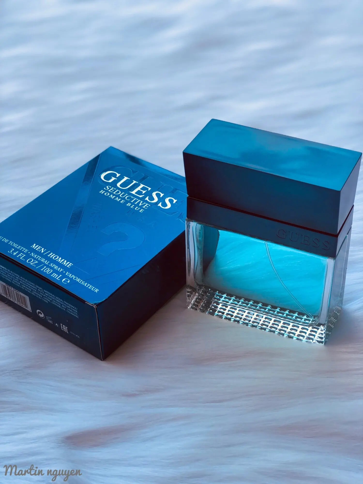 Guess perfume bottle and packaging on a textured surface