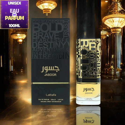 Jasoor Unisex Eau de Parfum 100ml bottle and its black packaging box, displayed on a reflective dark surface with a luxury interior background of golden chandeliers. A purple 'UNISEX EAU DE PARFUM 100ML' label is in the top-left corner.