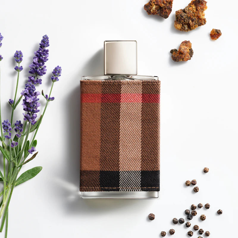 Perfume bottle with plaid design surrounded by lavender and spices on a white background