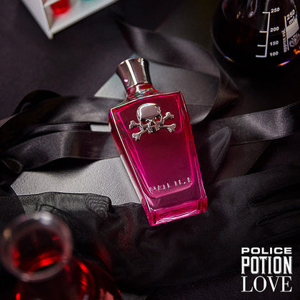Pink potion bottle with skull design on a dark fabric background, featuring the 'Police Potion Love' branding.
