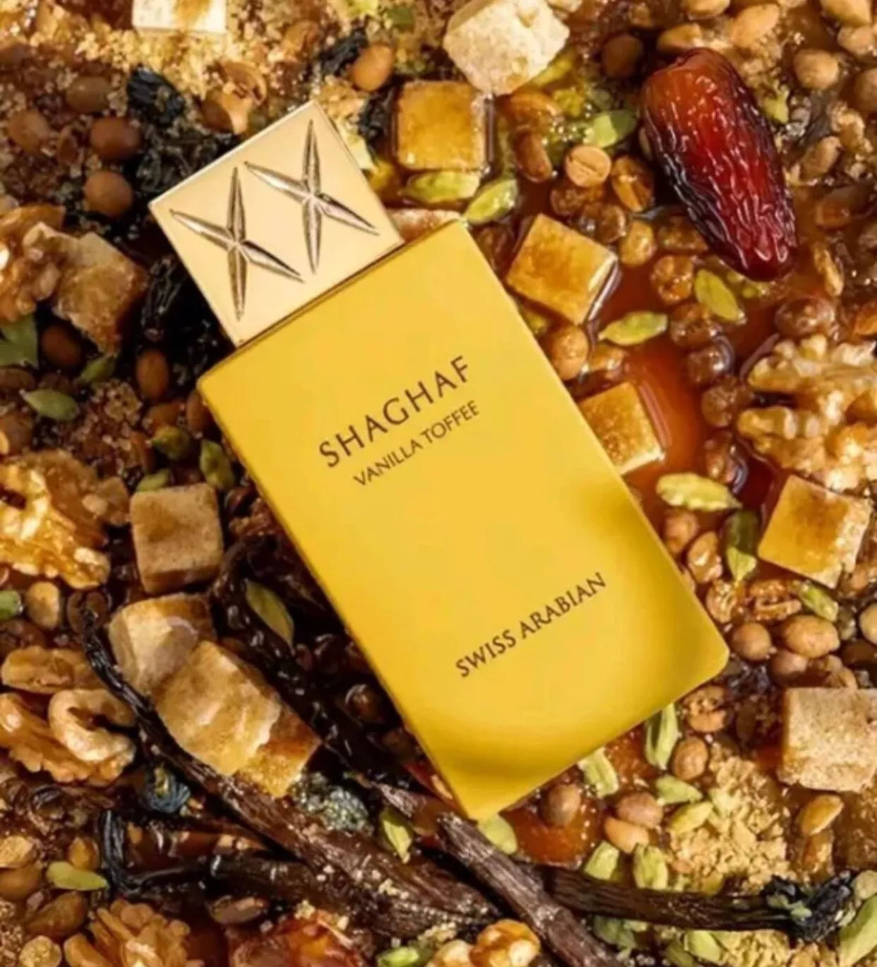Shaghaf Vanilla Toffee perfume bottle on a textured background with nuts and spices