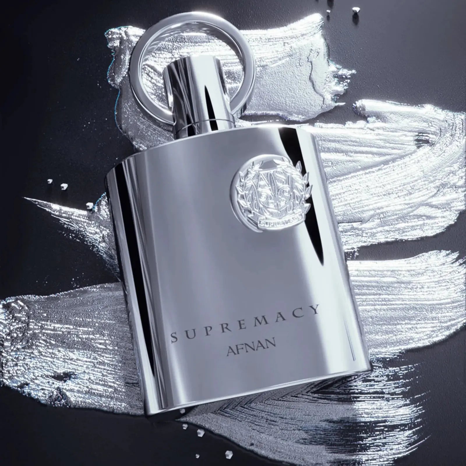Silver perfume bottle with diamond-like gem on a black and white abstract background, featuring the brand 'Supremacy Afnan'.