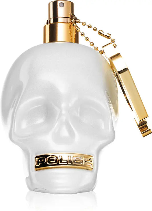 White skull-shaped perfume bottle with gold accents on a white background