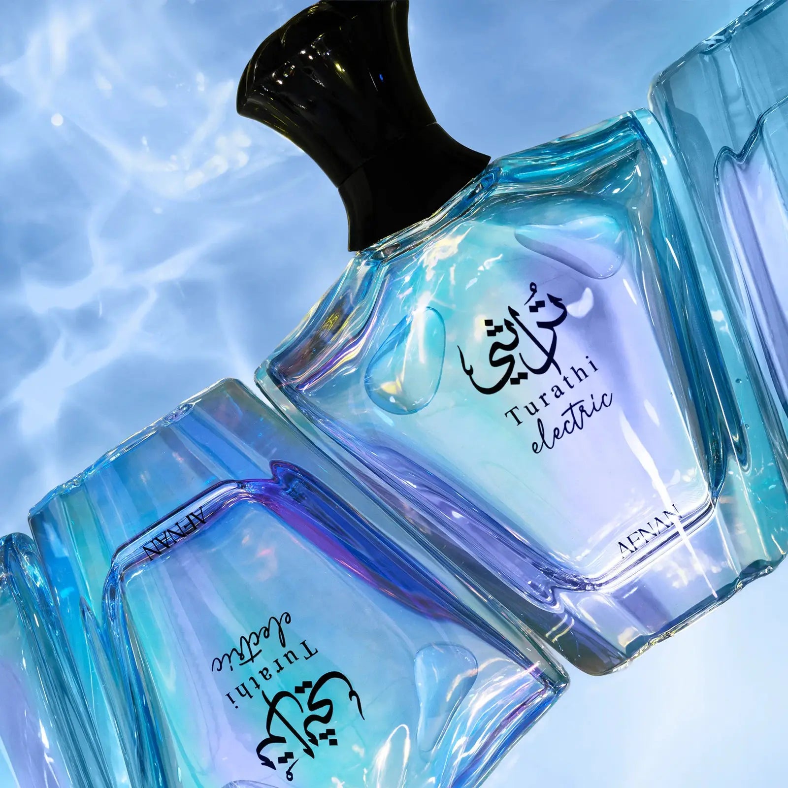 Two blue perfume bottles with 'Turaithi electric' text on a light blue background