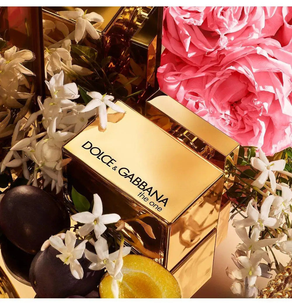 Dolce & Gabbana perfume bottle with flowers and chocolates on a white background